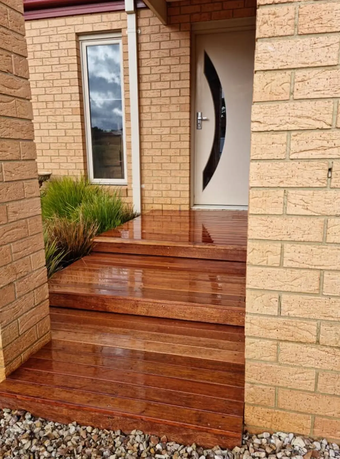 Freshly oiled hardwood entry steps and landing leading to a front door